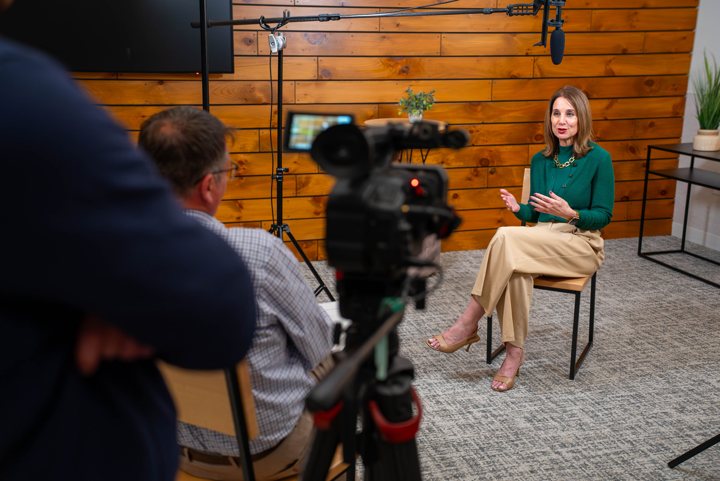 An interview being filmed with a camera and overhead microphone.